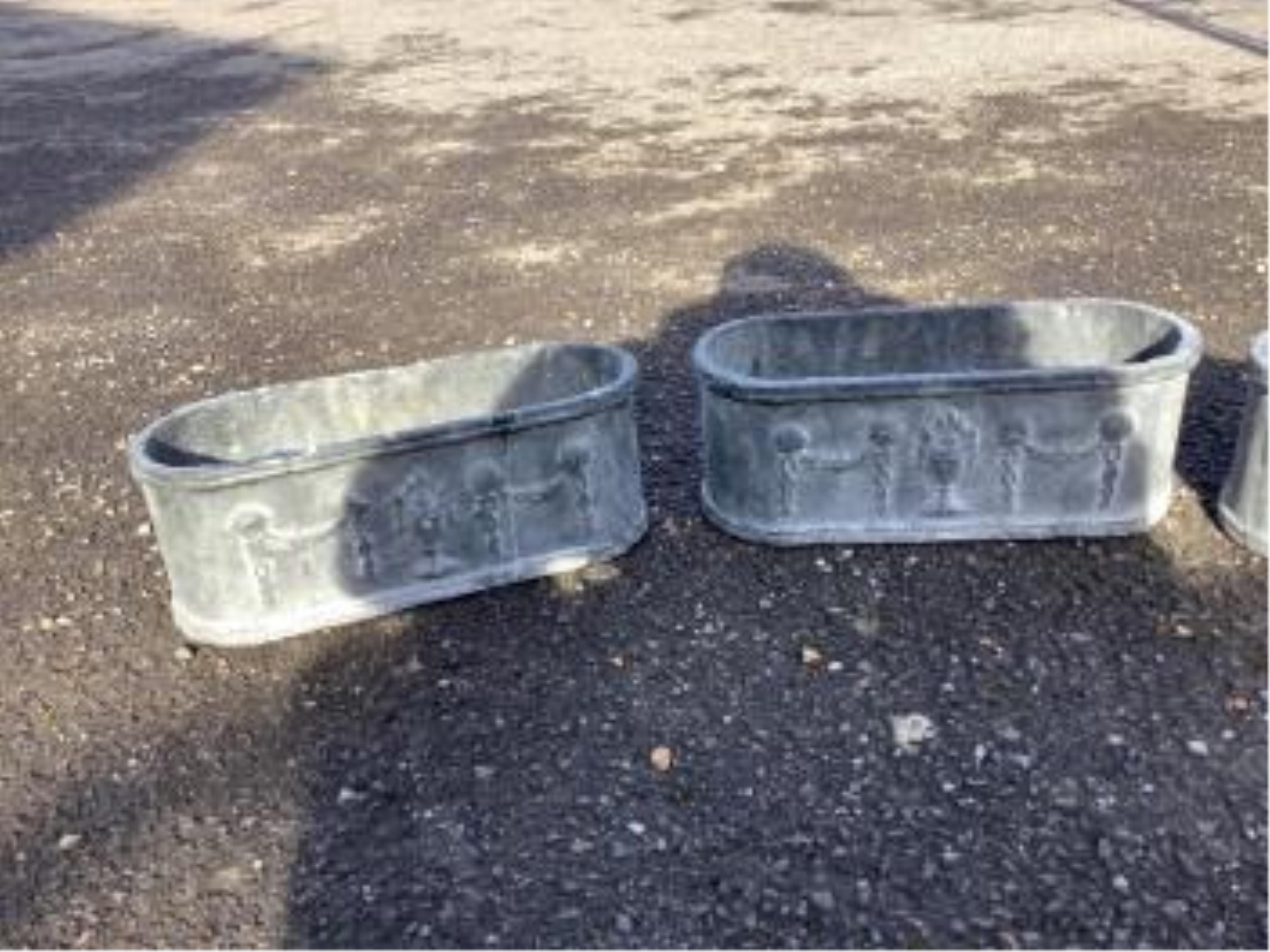 A set of four cast iron planters, width 36cm, and a pair of more ornate planters, width 48cm. Condition - weathered, otherwise good